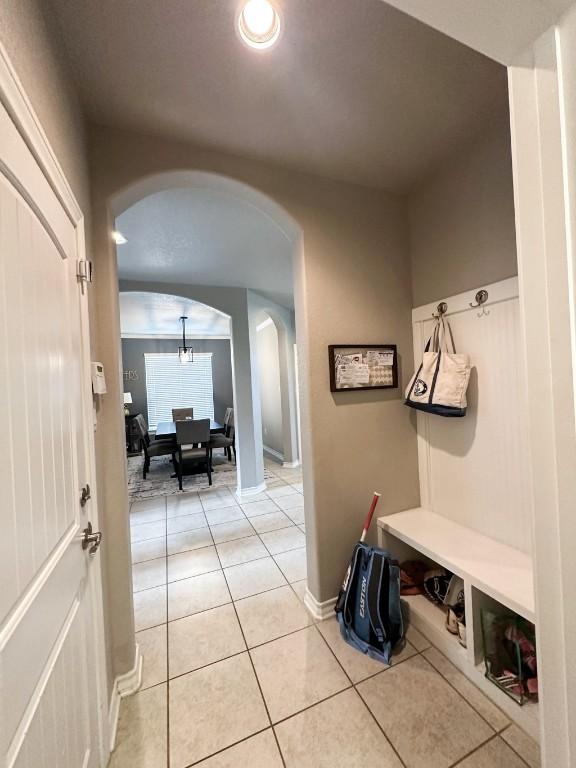 3119 Brand Iron Dr, San Marcos, TX 78666 - mudroom with arched walkways, light tile patterned floors, and baseboards