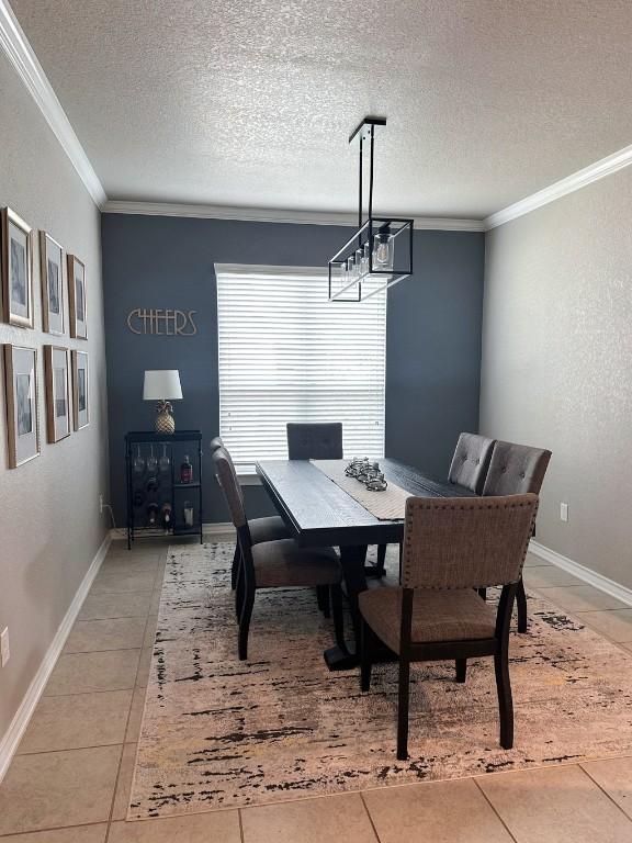 3119 Brand Iron Dr, San Marcos, TX 78666 - dining room featuring light tile patterned floors, crown molding, a textured ceiling, a chandelier, and baseboards