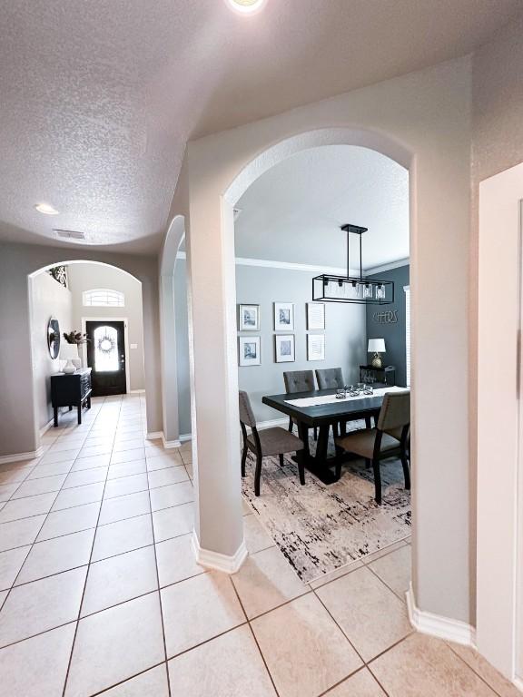 3119 Brand Iron Dr, San Marcos, TX 78666 - hall featuring arched walkways, light tile patterned floors, baseboards, an office area, and a textured ceiling