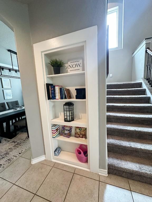 3119 Brand Iron Dr, San Marcos, TX 78666 - stairs with tile patterned floors, built in shelves, and baseboards