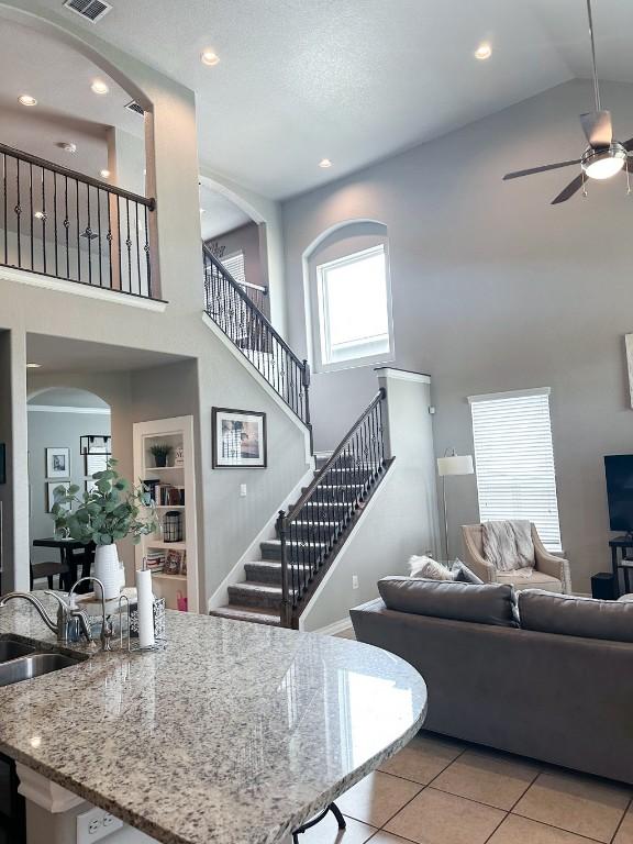 3119 Brand Iron Dr, San Marcos, TX 78666 - living room with a high ceiling, ceiling fan, light tile patterned flooring, stairway, and recessed lighting