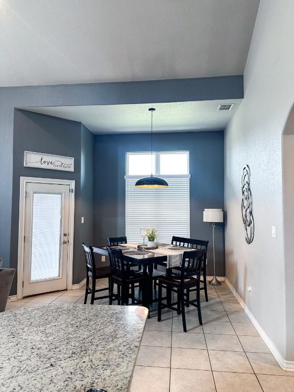3119 Brand Iron Dr, San Marcos, TX 78666 - dining room featuring light tile patterned flooring, baseboards, and arched walkways