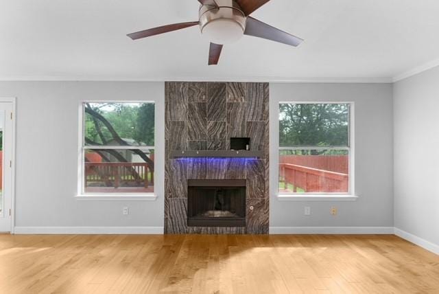 6200 La Naranja Ln, Austin, TX 78749 - unfurnished living room featuring wood finished floors, a fireplace, crown molding, baseboards, and ceiling fan