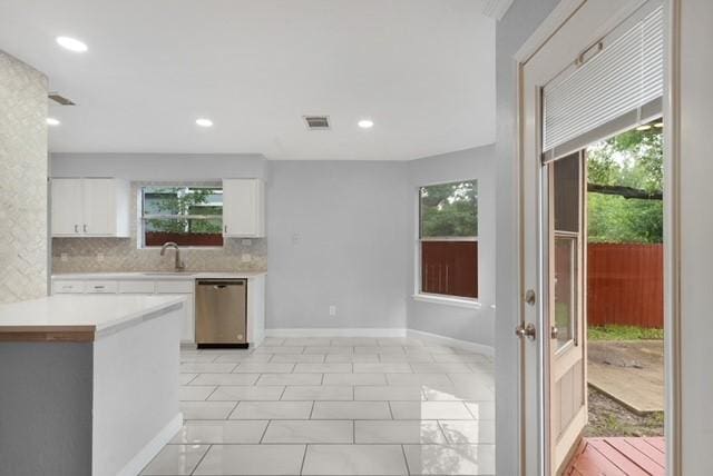 6200 La Naranja Ln, Austin, TX 78749 - kitchen with stainless steel dishwasher, light countertops, white cabinetry, healthy amount of natural light, and recessed lighting