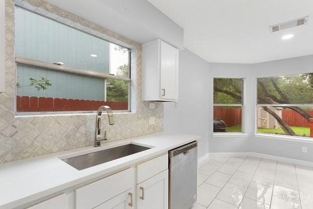 6200 La Naranja Ln, Austin, TX 78749 - kitchen featuring dishwasher, a sink, backsplash, light countertops, and white cabinetry