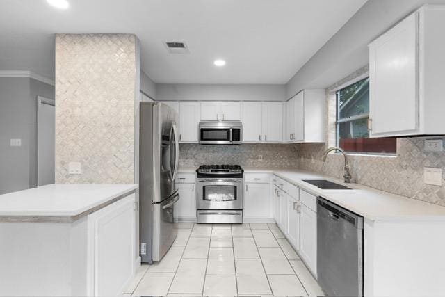 6200 La Naranja Ln, Austin, TX 78749 - kitchen featuring stainless steel appliances, a sink, white cabinetry, tasteful backsplash, and recessed lighting