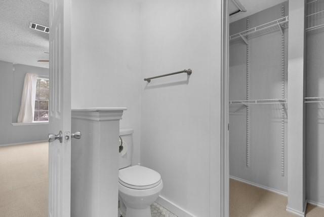 6200 La Naranja Ln, Austin, TX 78749 - bathroom featuring toilet, baseboards, and a textured ceiling