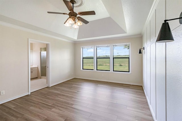 160 Turkey Run, Meadowlakes, TX 78654 - unfurnished bedroom with a raised ceiling, light wood-type flooring, crown molding, baseboards, and connected bathroom