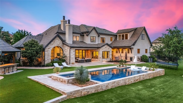 11705 Shoreview Overlook, Austin, TX 78732 - rear view of house with stone siding, stucco siding, an outdoor hangout area, and a chimney