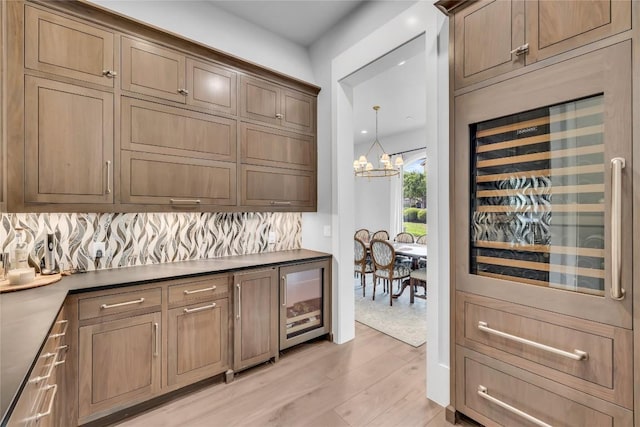 11705 Shoreview Overlook, Austin, TX 78732 - indoor dry bar with beverage cooler, backsplash, light wood-style flooring, and a chandelier