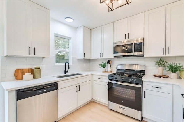 9606 Dallum Dr, Austin, TX 78753 - kitchen with appliances with stainless steel finishes, a sink, light countertops, white cabinets, and decorative backsplash
