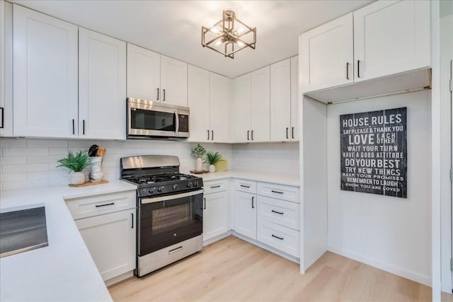 9606 Dallum Dr, Austin, TX 78753 - kitchen featuring range with gas cooktop, stainless steel microwave, light wood finished floors, light countertops, and a chandelier