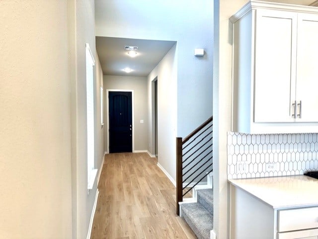 328 Milkwood Ter, Dripping Springs, TX 78620 - hall with light wood-style flooring, baseboards, and stairs
