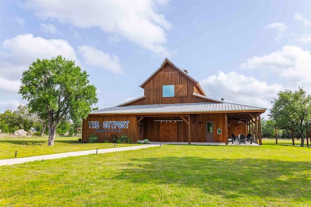 view of front of home with a front yard, metal roof, and a barn
