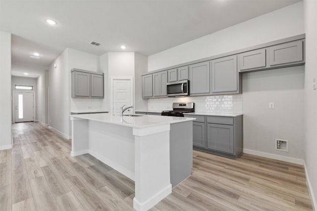 200 Hidalgo Ln, Elgin, TX 78621 - kitchen with gray cabinets, stainless steel microwave, gas stove, a sink, and recessed lighting