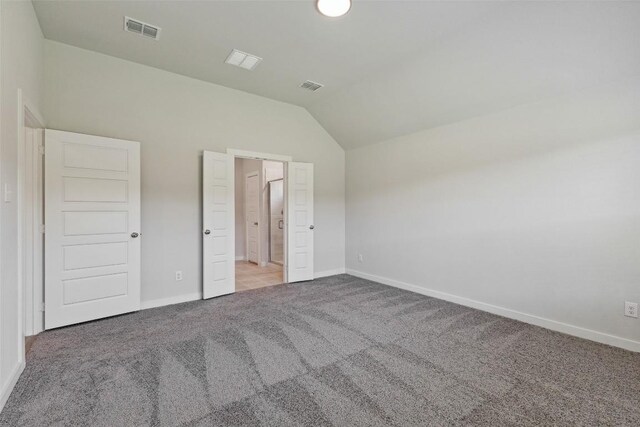 200 Hidalgo Ln, Elgin, TX 78621 - unfurnished bedroom featuring light carpet, vaulted ceiling, and baseboards