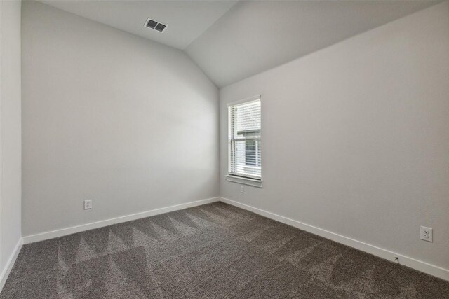 200 Hidalgo Ln, Elgin, TX 78621 - empty room featuring dark carpet, lofted ceiling, and baseboards