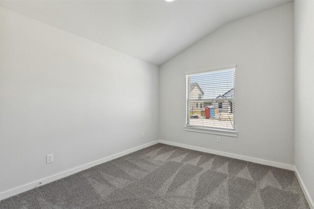 200 Hidalgo Ln, Elgin, TX 78621 - unfurnished room with lofted ceiling, dark carpet, and baseboards