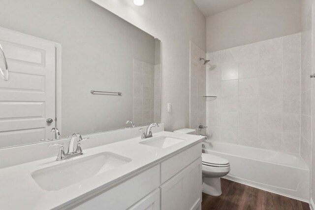 200 Hidalgo Ln, Elgin, TX 78621 - full bath with toilet, double vanity,  shower combination, and wood finished floors