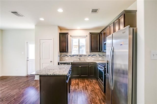 253 Beechnut Dr, Buda, TX 78610 - kitchen with stainless steel appliances, a sink, a kitchen island, dark brown cabinets, and recessed lighting