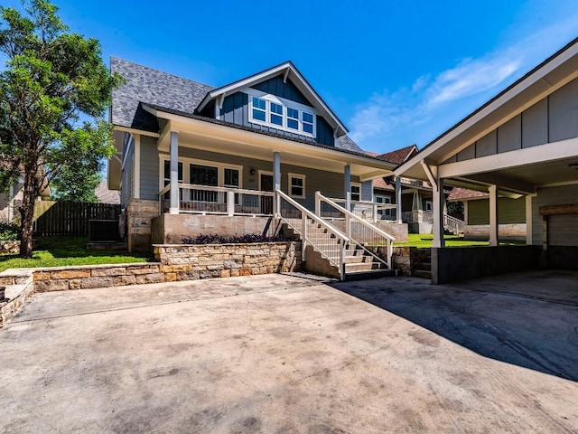 view of front of home featuring board and batten siding, a porch, a shingled roof, and central AC unit