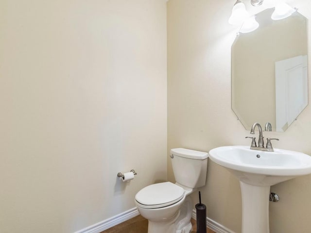 half bath with toilet and baseboards