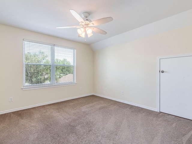 carpeted empty room featuring ceiling fan and baseboards