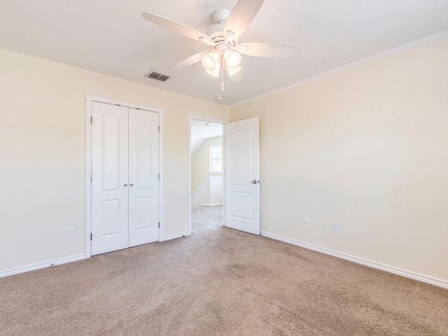 unfurnished bedroom featuring carpet flooring, baseboards, a closet, and a ceiling fan