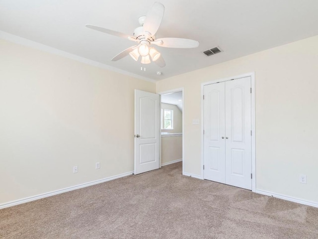 unfurnished bedroom with carpet flooring, a closet, baseboards, and a ceiling fan