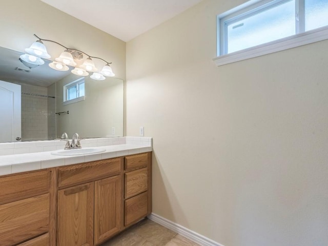 bathroom featuring vanity, baseboards, and a shower