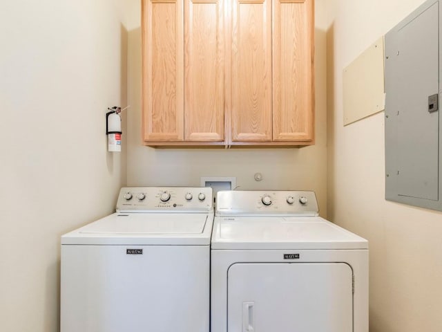 washroom with cabinet space, independent washer and dryer, and electric panel