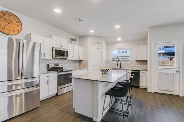 216 Xanadu Dr, Jarrell, TX 76537 - kitchen with appliances with stainless steel finishes, white cabinets, dark wood finished floors, and recessed lighting