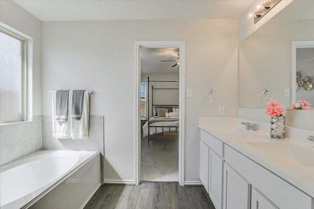 216 Xanadu Dr, Jarrell, TX 76537 - full bathroom with wood finished floors, a bath, ensuite bathroom, double vanity, and baseboards