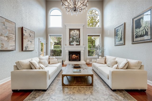 2116 Demona Dr, Austin, TX 78733 - living area with a textured wall, a chandelier, wood finished floors, a warm lit fireplace, and a high ceiling