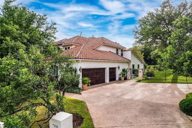 2116 Demona Dr, Austin, TX 78733 - mediterranean / spanish-style home with driveway, an attached garage, stucco siding, fence, and a tiled roof
