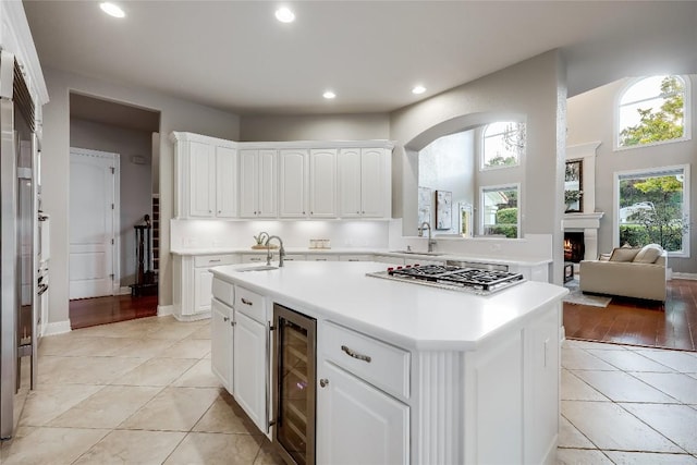 2116 Demona Dr, Austin, TX 78733 - kitchen featuring stainless steel gas stovetop, beverage cooler, light tile patterned floors, healthy amount of natural light, and recessed lighting