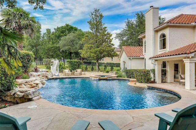 2116 Demona Dr, Austin, TX 78733 - view of pool featuring a water slide, a patio area, fence, and a pool with connected hot tub