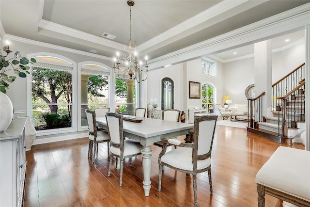 2116 Demona Dr, Austin, TX 78733 - dining space with plenty of natural light, stairs, wood-type flooring, a chandelier, and crown molding