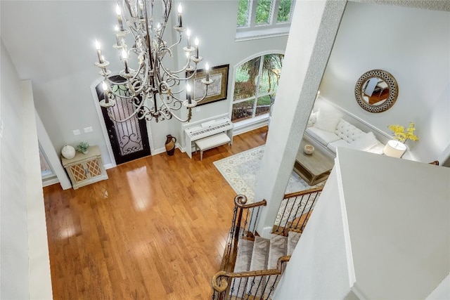 2116 Demona Dr, Austin, TX 78733 - foyer with a chandelier, wood finished floors, and stairway