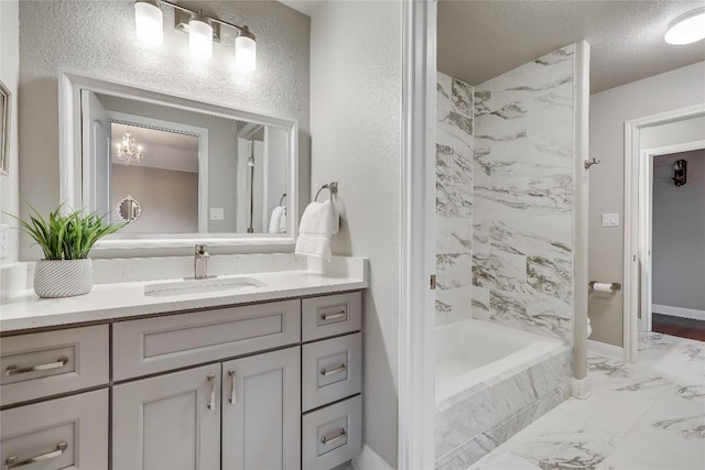 2116 Demona Dr, Austin, TX 78733 - bathroom featuring vanity, marble look tile flooring, a combined bath / shower with marble appearance, and a textured ceiling