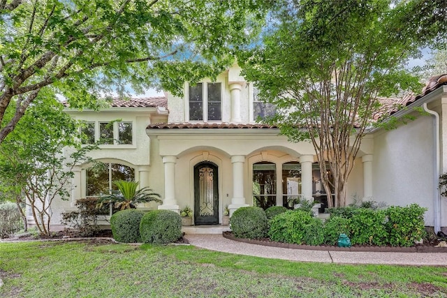 2116 Demona Dr, Austin, TX 78733 - view of front facade with stucco siding, a tiled roof, and a front yard
