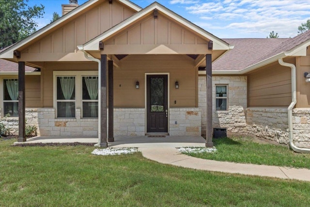 113 N Buckhorn Dr, Bastrop, TX 78602 - craftsman house with board and batten siding, stone siding, a front yard, a chimney, and roof with shingles