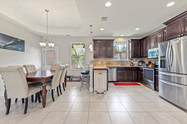 113 N Buckhorn Dr, Bastrop, TX 78602 - kitchen with stainless steel appliances, decorative backsplash, light countertops, dark brown cabinetry, and recessed lighting