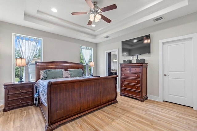113 N Buckhorn Dr, Bastrop, TX 78602 - bedroom with a raised ceiling, light wood-style floors, multiple windows, baseboards, and recessed lighting