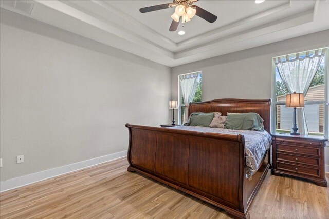 113 N Buckhorn Dr, Bastrop, TX 78602 - bedroom featuring light wood finished floors, a tray ceiling, recessed lighting, baseboards, and a ceiling fan