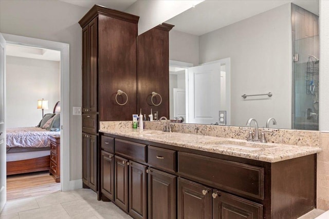 113 N Buckhorn Dr, Bastrop, TX 78602 - ensuite bathroom featuring double vanity, tile patterned floors, and a shower with shower door