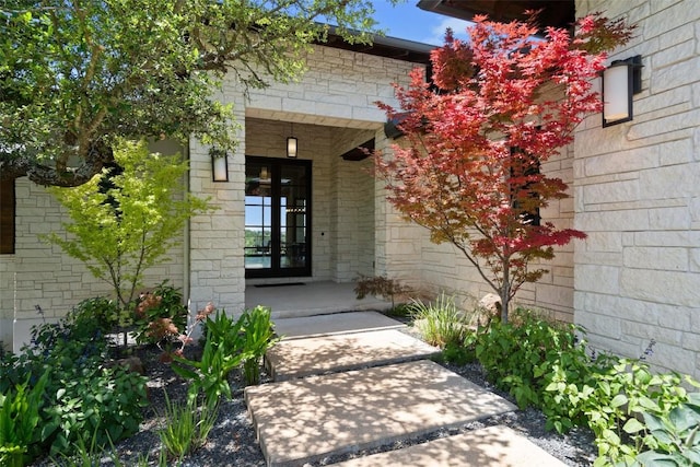 property entrance with covered porch and stone siding