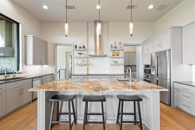 kitchen with appliances with stainless steel finishes, open shelves, a sink, wall chimney range hood, and recessed lighting
