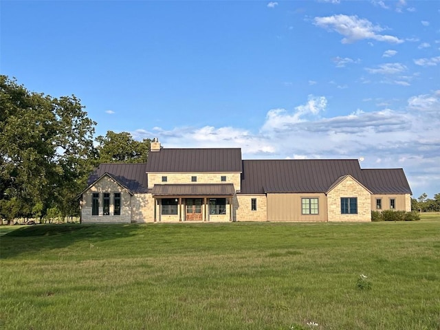 1402 Countryside Bnd, Fredericksburg, TX 78624 - view of front of property with a standing seam roof, a front yard, a chimney, stone siding, and metal roof
