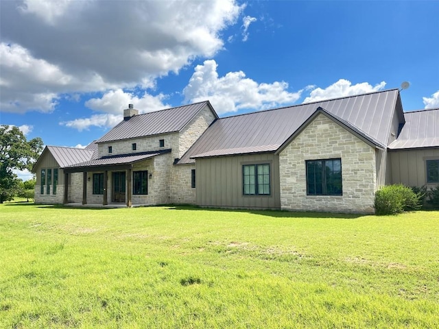1402 Countryside Bnd, Fredericksburg, TX 78624 - rear view of property with board and batten siding, metal roof, a yard, stone siding, and a standing seam roof